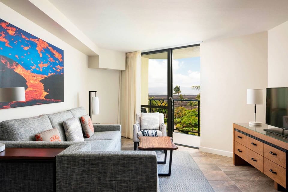 Separate living room features a sleeper sofa, TV, and door to another patio.