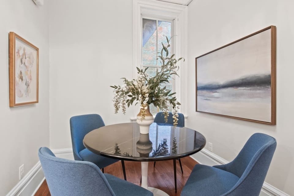 Unit #2 (2 of 3,  Second Floor) Enjoy a delightful meal in this cozy dining nook with modern artwork and natural light. Perfect for intimate gatherings and memorable moments. Dine in style at your home away from home. ️️