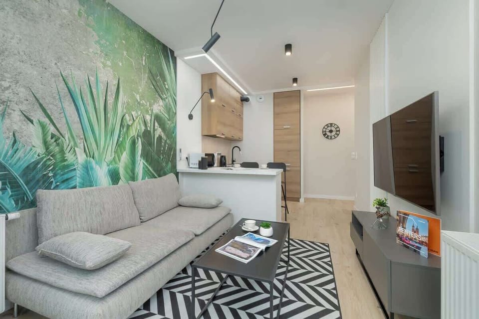 Another angle of the living room, highlighting the sofa, coffee table, and the lush wallpaper that adds a lively touch to the interior.

