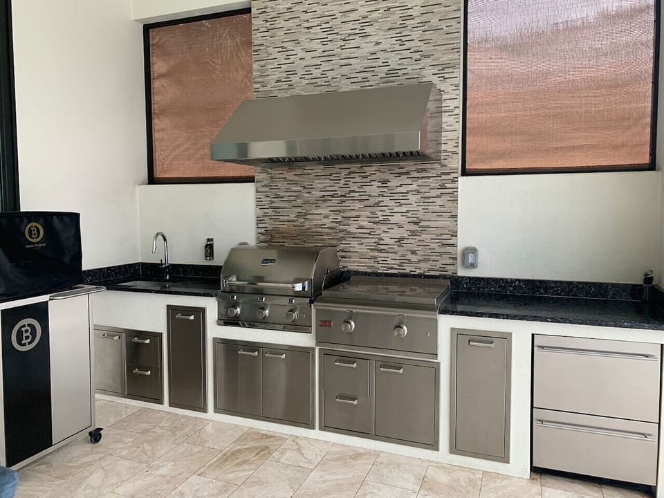 Modern outdoor kitchen with stainless steel grill and ample counter space for entertaining.
