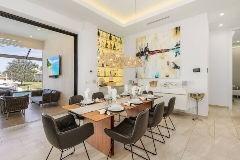 Elegant dining area with modern art and a view of the patio and pool.