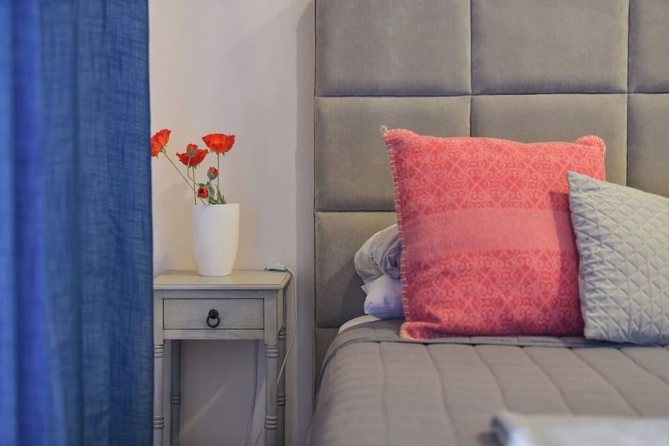 2 night stands on each side of the bed, along with a clothes closet for hanging and drawers for storage and folding.