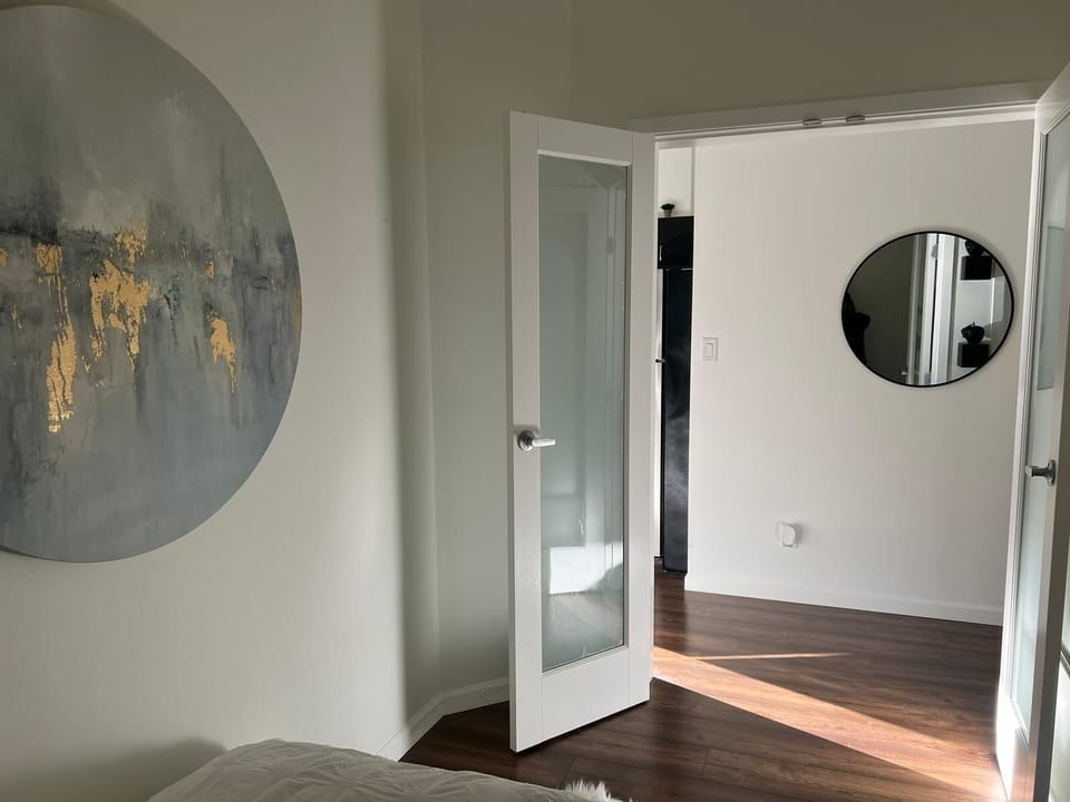 Bright interior hallway view framed by a glass-paneled accent door.