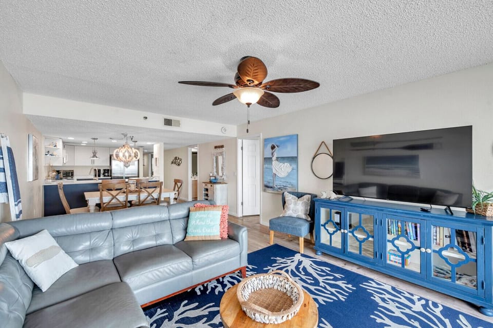 Comfortable living room setup w/ TV, coastal touches, and an open, relaxed layout.