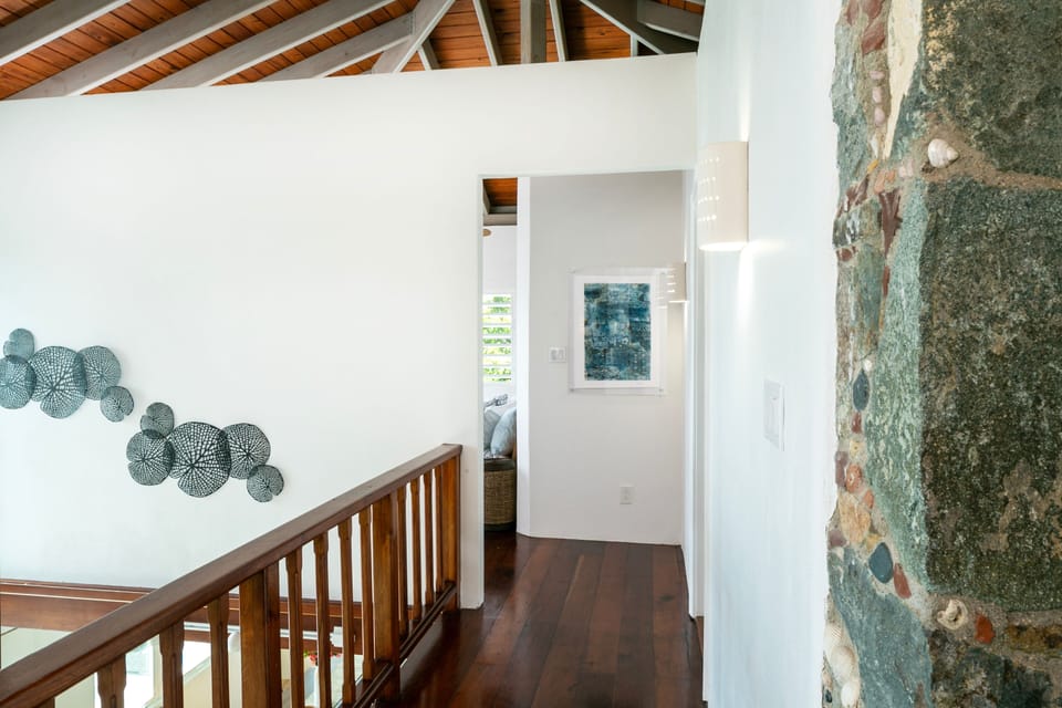 The spiral staircase and a hallway leads to the main house bedroom
