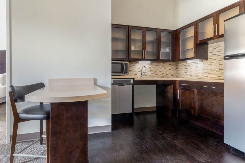 Fully equipped kitchen with dark cabinetry and modern appliances.