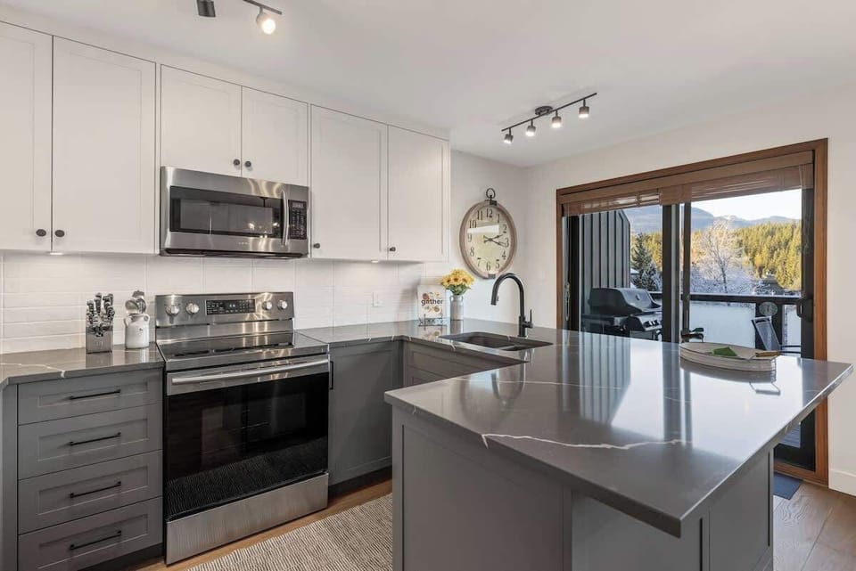 - Cook in a modern kitchen with stainless steel appliances and sleek countertops  
- Gather around the island for breakfast with a view of Whistler’s snow-covered peaks  
- Step through sliding doors to enjoy outdoor dining on the balcony grill area 
