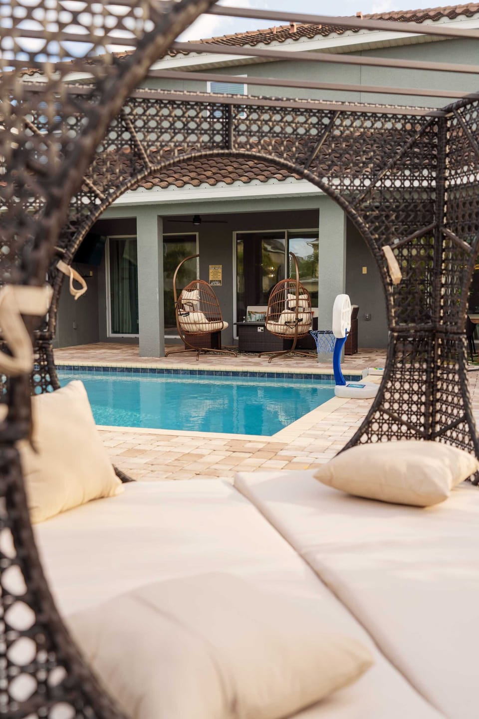Relax in style by your private pool with cozy lounge and hanging chairs, perfect for unwinding under the sun.