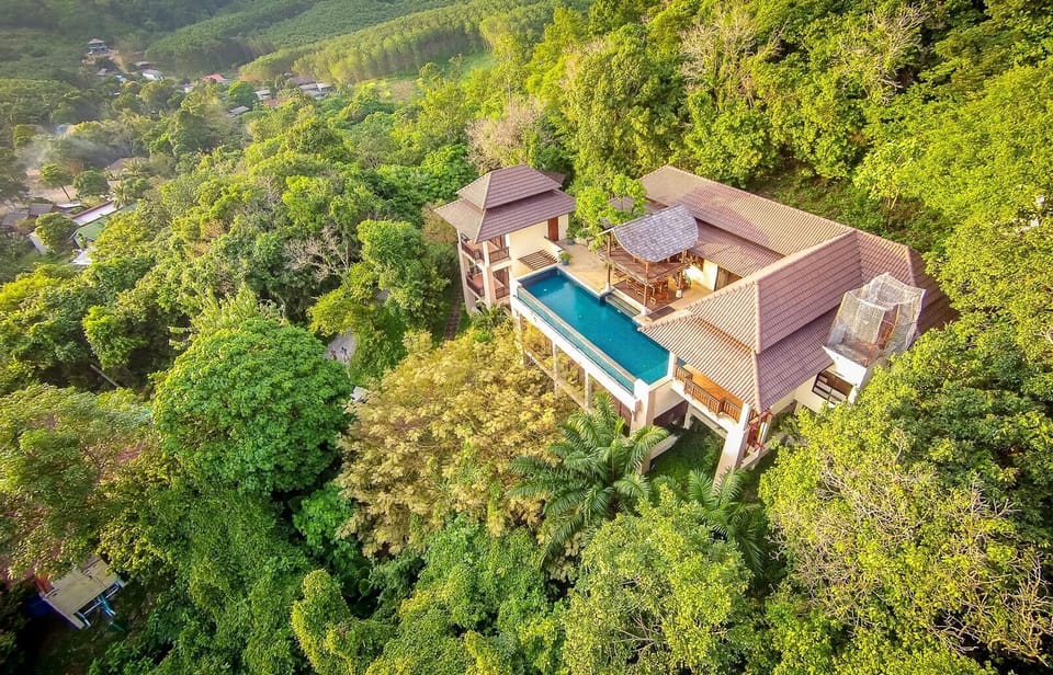 Aerial view of the villa nestled in the rainforest above the bay