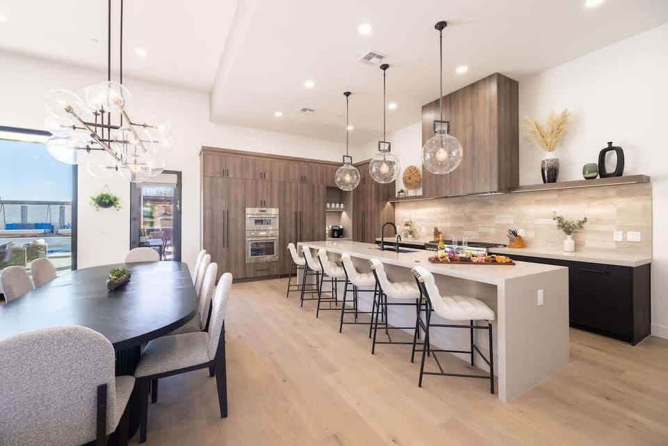 Gourmet kitchen with waterfall island, bar seating, and statement lighting throughout