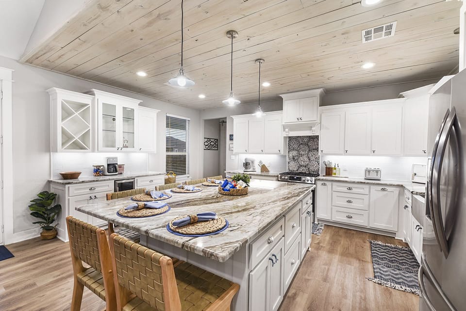 Kitchen with stainless steel appliances, gas range, mini bar.