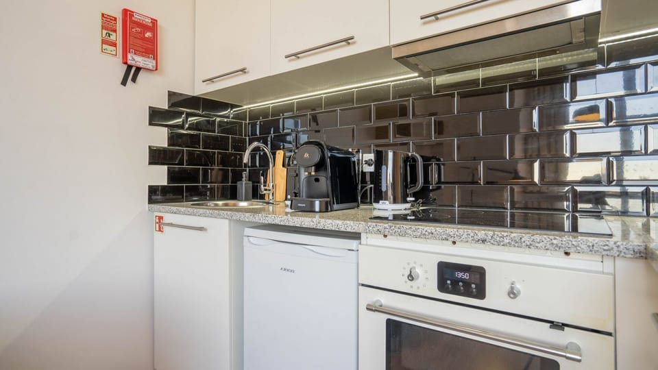 A compact yet functional kitchenette equipped with essential appliances like a mini-fridge, microwave and coffee maker. It's ideal for preparing light meals and snacks during your stay #modern #practical