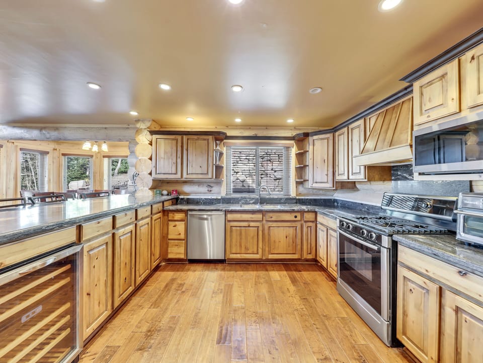 Fully stocked kitchen with pots, pans, utensils, spices, and various appliances