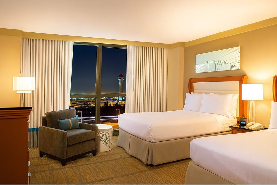 Unwind in plush beds while city lights sparkle below.