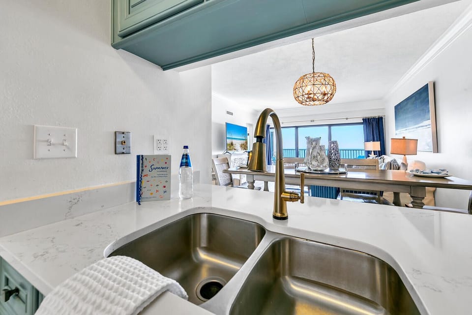 Your modern kitchen overlooks the sparkling gulf, where preparation becomes pure pleasure with gleaming counters and stunning sea views.