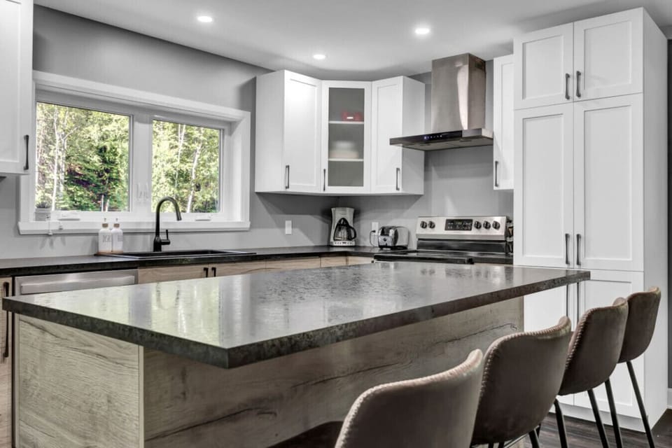 Fully equipped kitchen with quartz island and stainless appliances.
