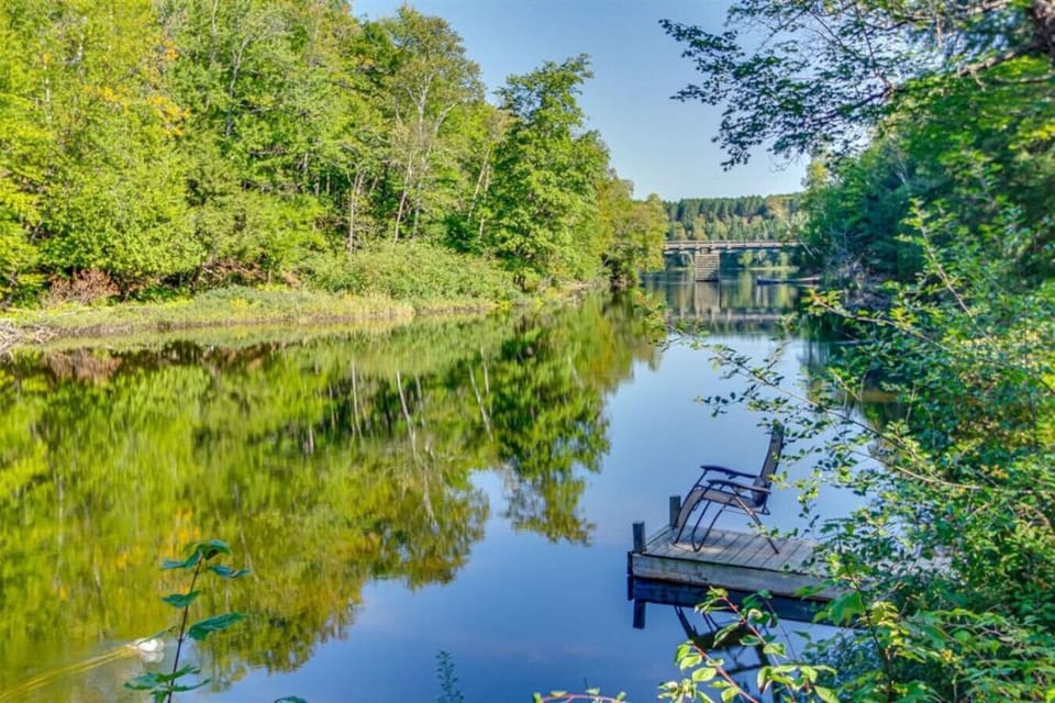 A private dock extends out over the calm river.
