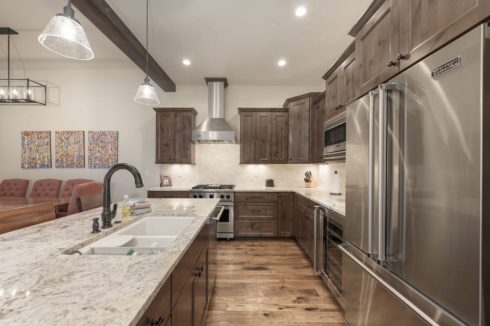 - Spacious open kitchen with rich wood cabinetry and modern appliances - Long granite island with bar seating great for prep snacks or chatting - Fully stocked and ready for cooking up your group’s favorite meals