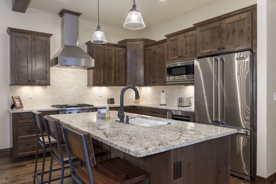 - Chef’s kitchen with granite counters pendant lighting and modern finishes - Stainless steel appliances and bar seating make it both stylish and functional - Cook up mountain meals while staying connected to the living space