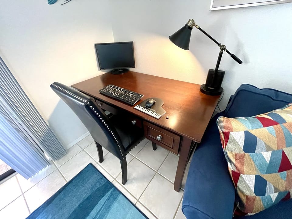 Work desk with monitor, wireless keyboard and mouse.