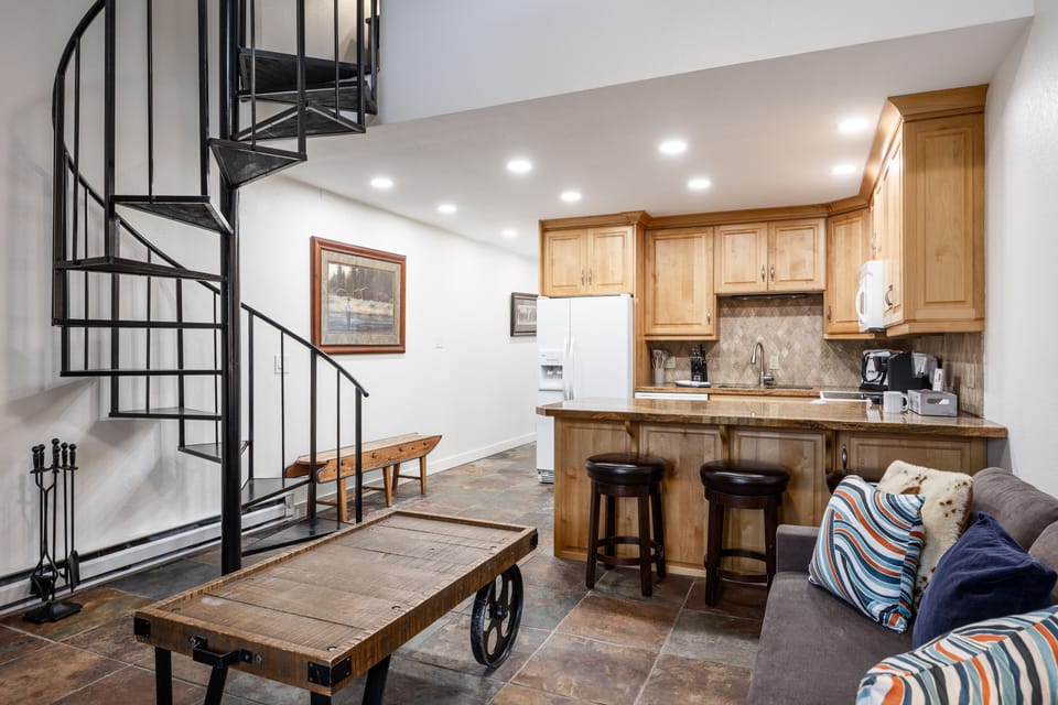 - Open floor plan with spiral staircase feature  
- Kitchen and living room designed for comfort  
- Ideal Park City vacation rental near the slopes