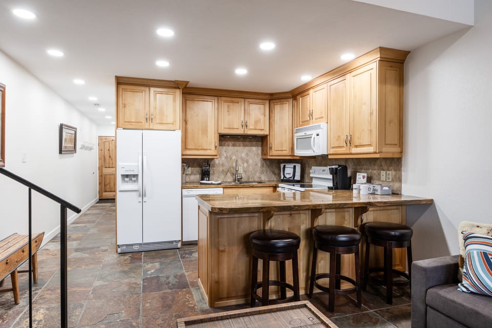 - Full kitchen with granite countertops and wood cabinets  
- Modern appliances for easy vacation cooking  
- Breakfast bar with stools for casual dining