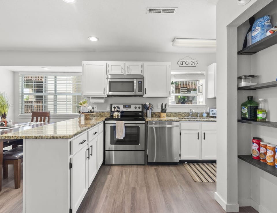 Fully equipped kitchen with stainless steel appliances, coffee and creamer 