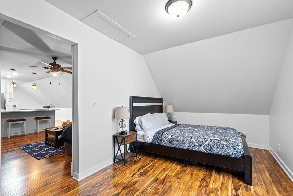 Your cozy bedroom features rich hardwood floors and thoughtful lighting, connecting seamlessly to the modern kitchen for ultimate comfort.
