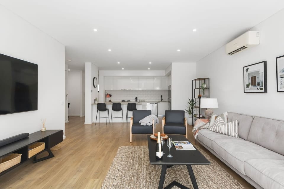 The designer living area is tastefully decorated with a plush sofa and leather armchairs. Kick back with a spot of TV after a day at the beach.