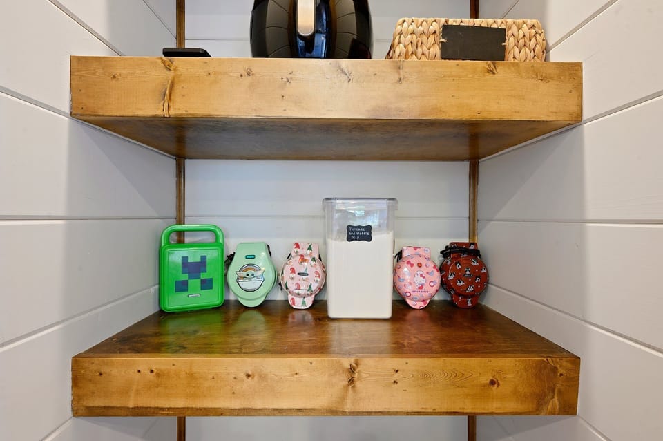Shelf with 5 Marvel, Christmas, Baby Yoda waffle makers and waffle mix.
