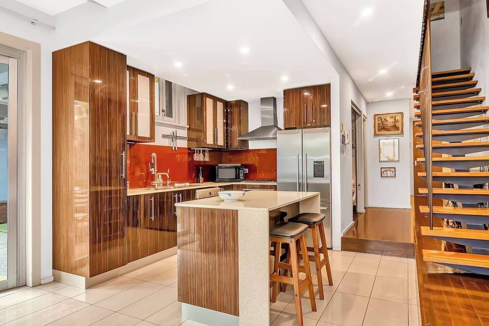 The modern kitchen revolves around a central island and is equipped with all the essentials to cook at home.