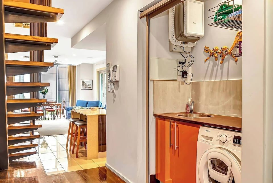 The laundry is home to a washing machine and a small sink.
