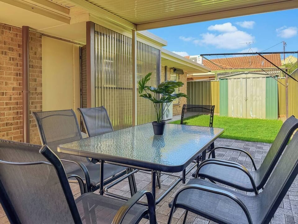 Savour relaxed outdoor meals or sip morning coffee under the covered patio, featuring a six-seater setting and views of the lush backyard.