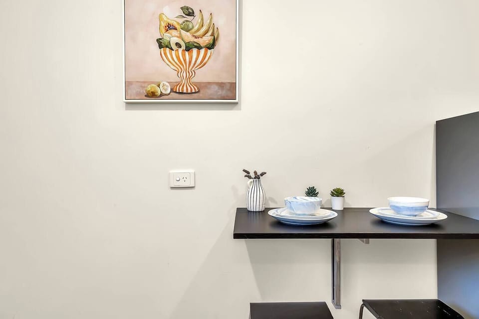 Enjoy quick bites or a morning coffee at the compact built-in bar with stools, neatly tucked beside the fridge for a space-saving dining spot.