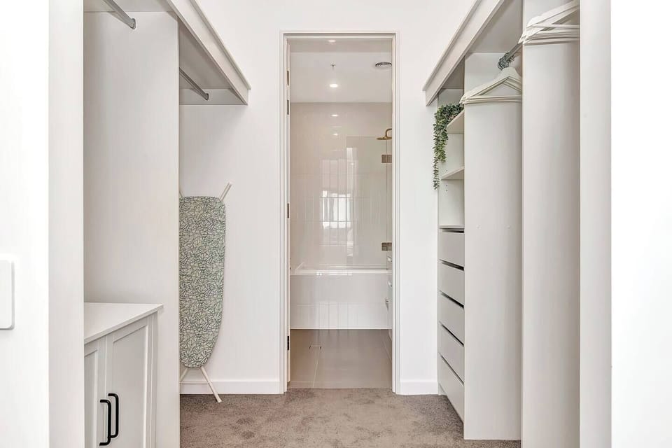 The master bedroom features a spacious walk-in wardrobe leading through to the ensuite. 
