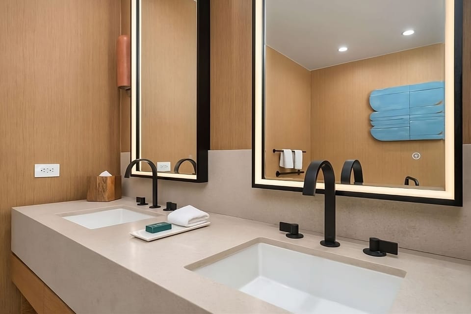 Refresh at the spacious double vanity with elegant, warm lighting.