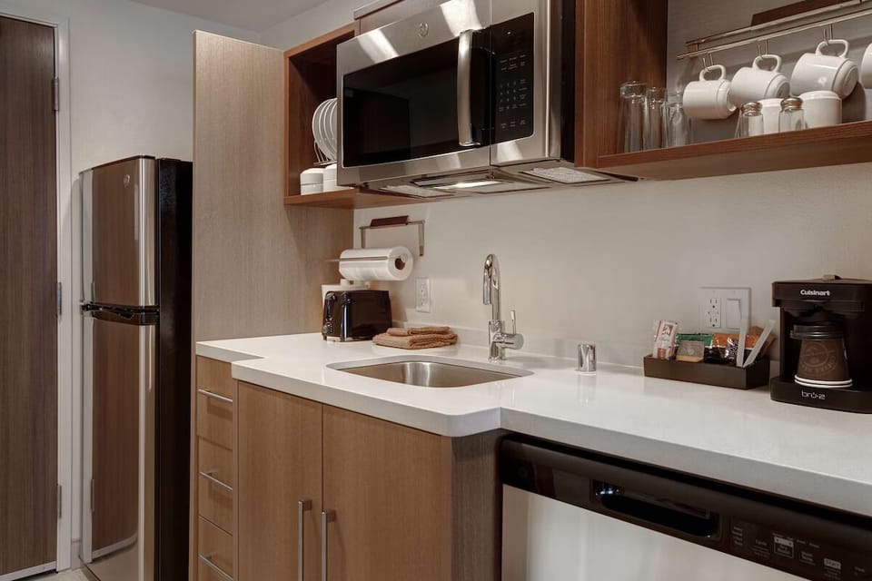 Prepare easy snacks with fridge, microwave, sink, and coffee setup.