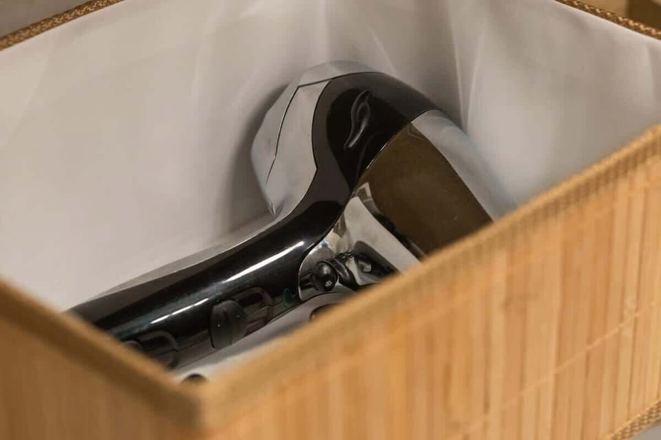 A close-up of a storage basket containing a hairdryer.

