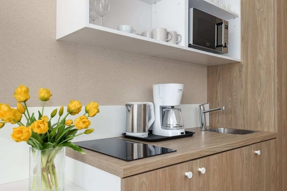Another view of the kitchen with a wooden finish and bright yellow tulips as decor.

