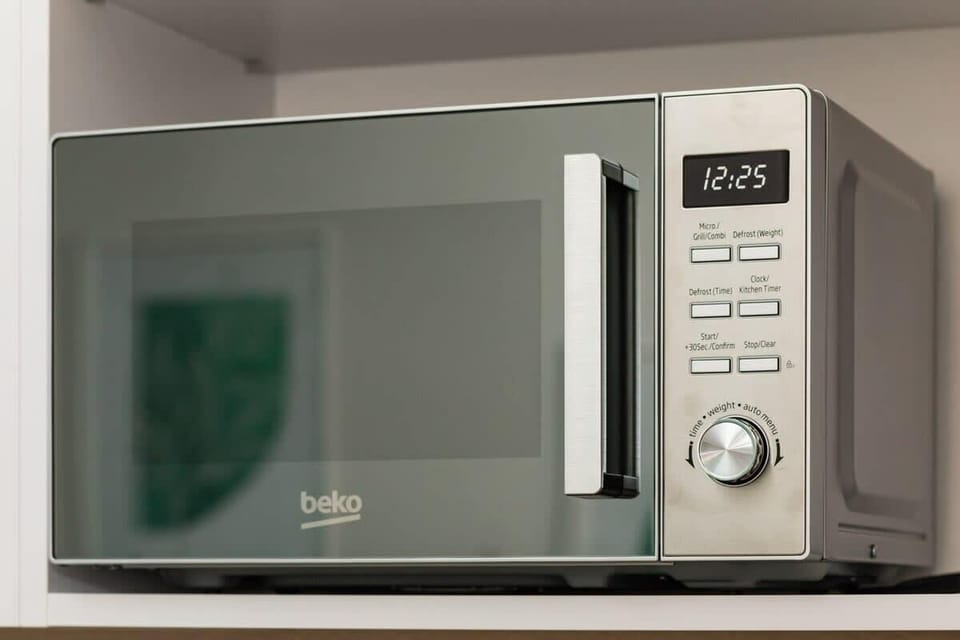 A close-up of a modern microwave with a digital display.

