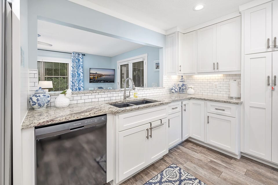 Kitchen – Bright, Updated & Fully Equipped - This St. Simons Island vacation rental features a modern kitchen with granite countertops, white shaker cabinets, and a full suite of appliances—perfect for prepping beach day snacks or seafood dinners.