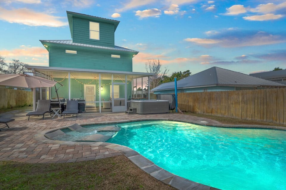 The back of the house offers an exquisite view, with a charming pool and a breathtaking sky that creates the perfect serene backdrop