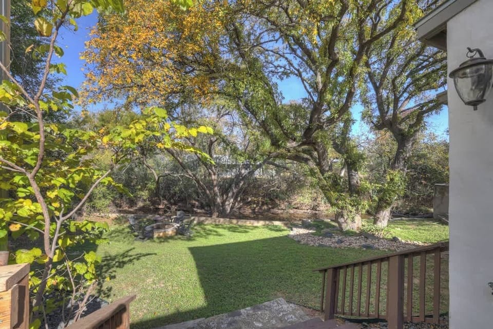 The lush backyard is a communal space on the property that features a firepit. 