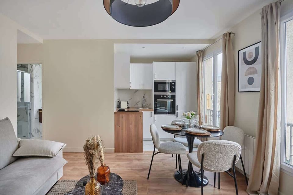 Salon avec canapé lit , cuisine américaine et coin repas