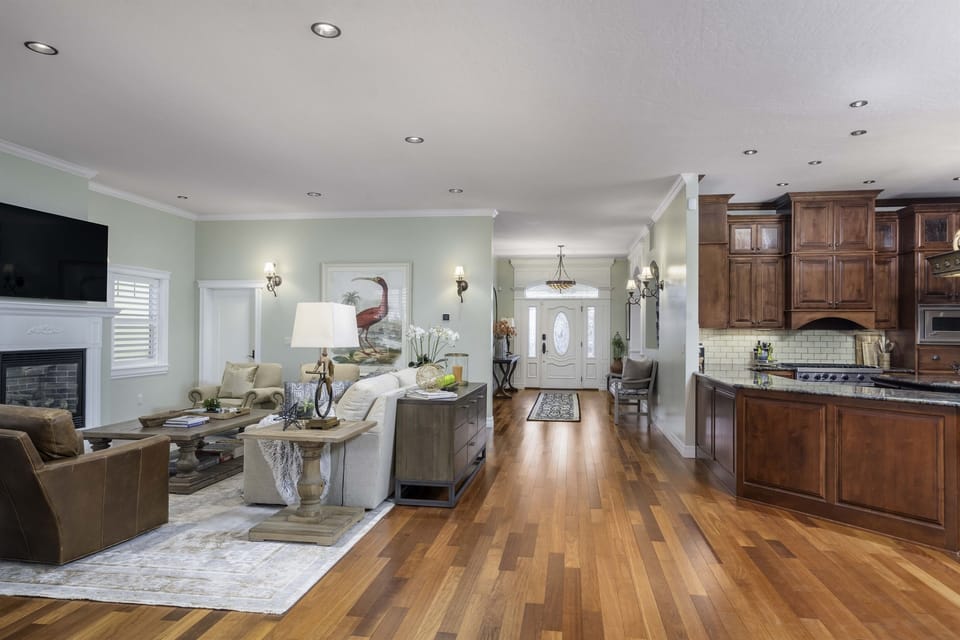 View from dining area to great room (in left), kitchen (in right), and entry.