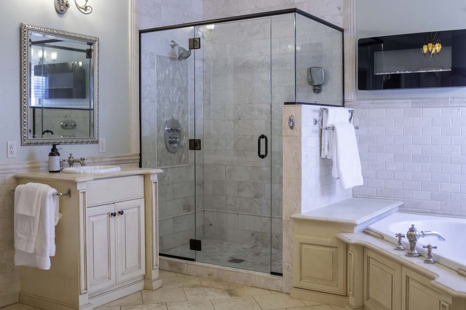 Master bedroom is an ensuite with a shower and tub, and two sinks.