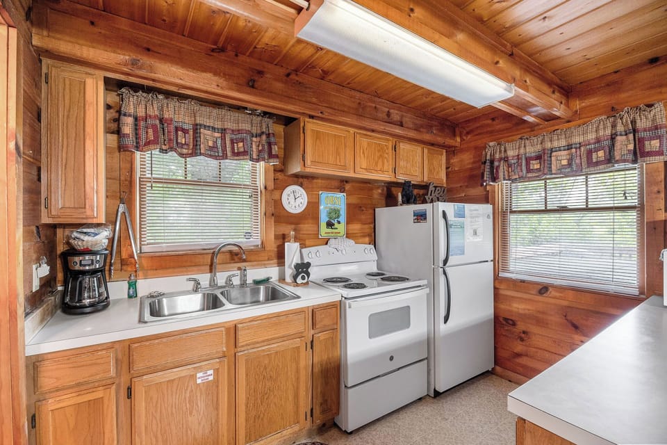 Kitchen with white appliances at Beary Good Time, a 1-bedroom cabin rental located in Pigeon Forge