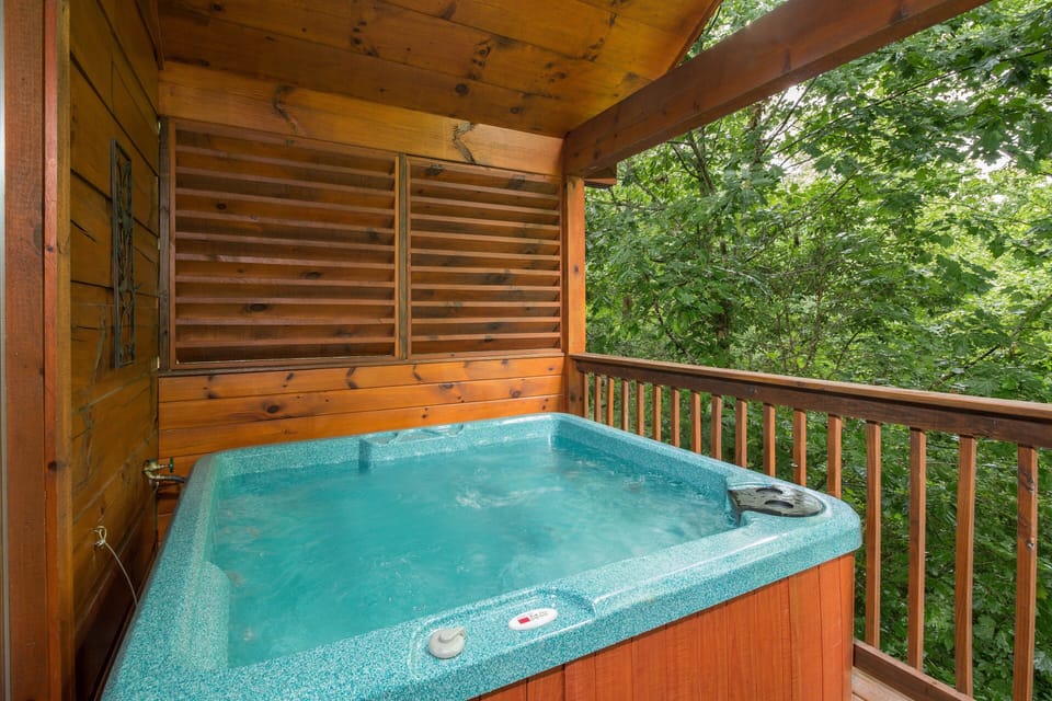 Hot tub on a covered deck at Kelly's Cabin, a 1 bedroom cabin rental located in Pigeon Forge