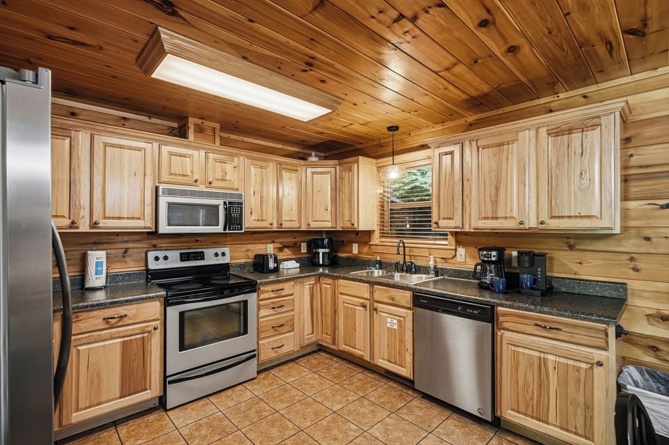 Prepare your favorite meals in this fully equipped kitchen with warm wood cabinetry, granite countertops, and all the modern appliances you need.