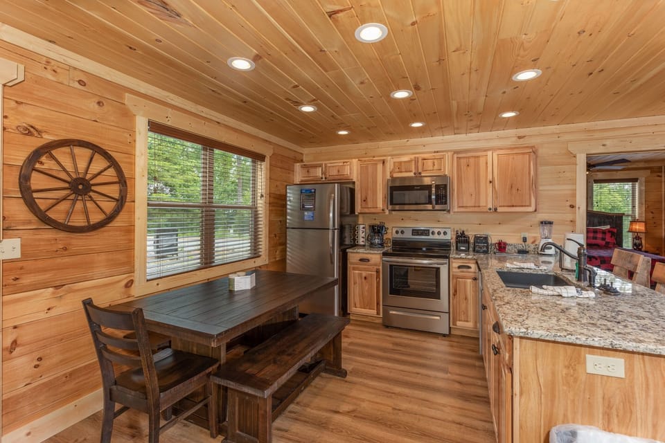 Full kitchen with appliances and dining table and seats